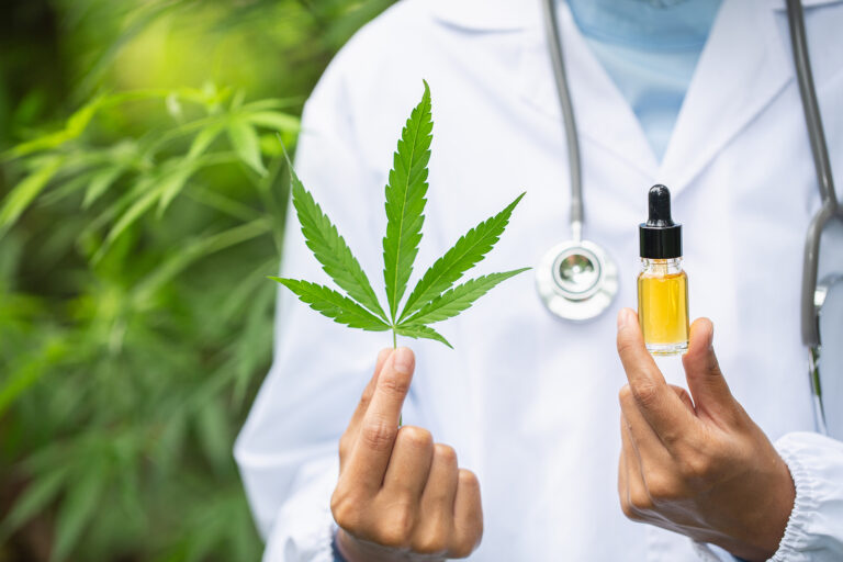 Arzt hält Hanfblatt und Flasche CBD Öl